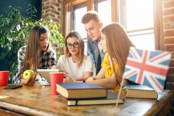 group-students-sitting-desk-looking-tablet-doing-homework_280538-3075