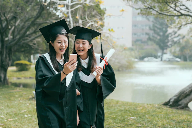 two-asian-girls-graduates-browsing-online-website-recruitment-employment-search-finding-job-ready-work-together-smart-phone-happy-college-students-with-certificate-trail-by-pond-smiling_678158-1719